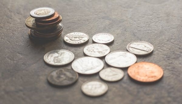 A pile of coins sitting on top of the floor.