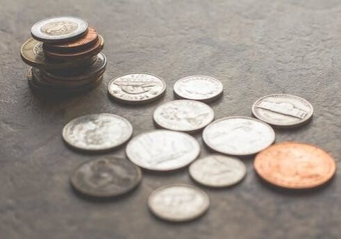 A pile of coins sitting on top of the floor.